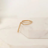 Yellow gold Delicate Trio Stacking Rings laid on a white marble surface and background.