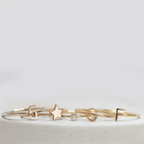 Two 14k gold Letter Rings (C and F), a Lucky Number Ring (5), a Twinkle Twinkle Ring and a Birthstone Ring, against a light grey background.