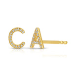 Gold pave earrings with C and A letters on a white background. 