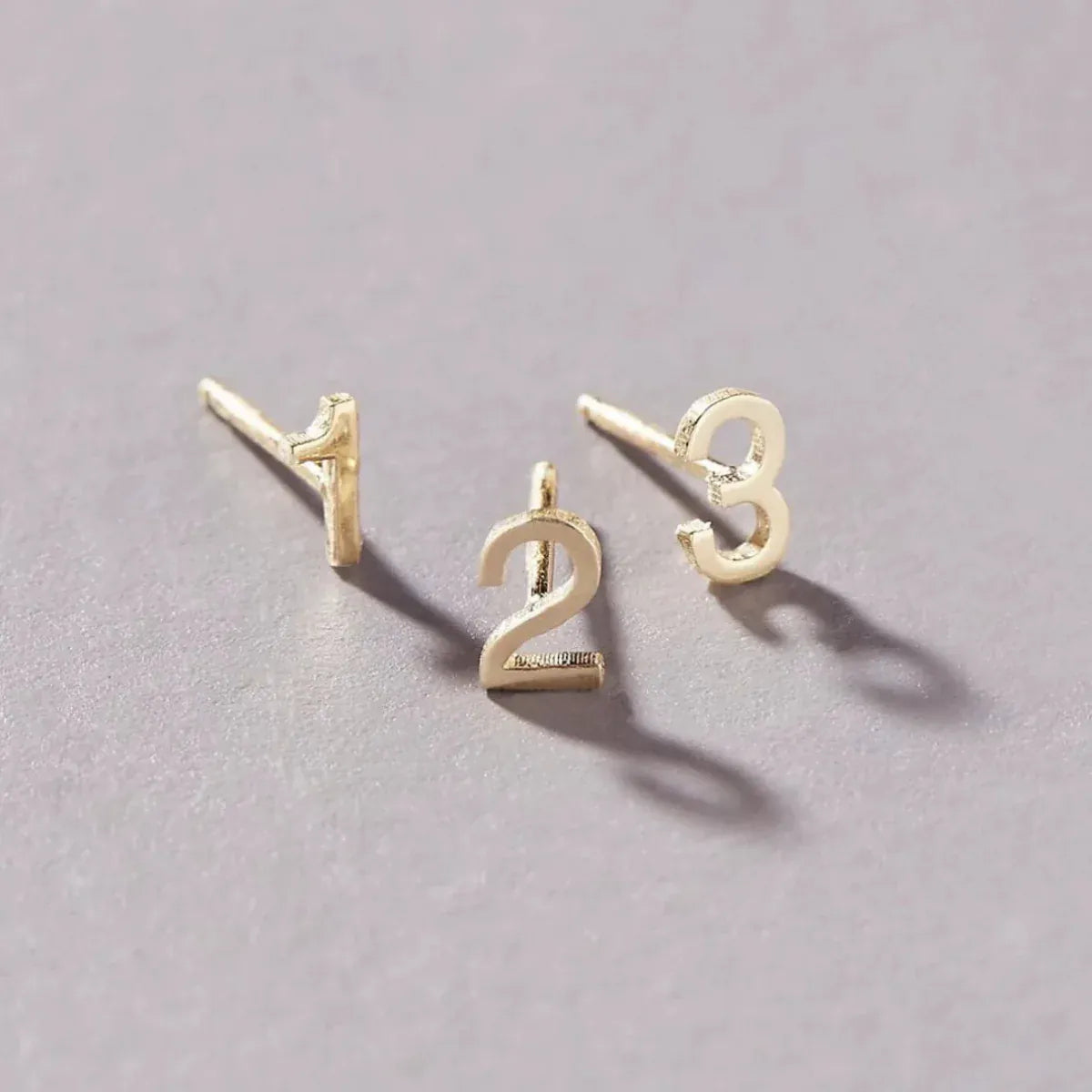 14K Gold Number Studs in 1, 2 and 3 against a light grey background. 