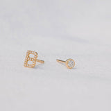 A Pavé Monogram Earring Set in the letter B in yellow gold on a light grey background. 