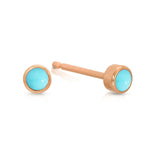 A pair of Birthstone Studs - Turquoise (December) in rose gold on a white background.