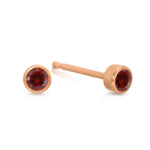 A pair of Birthstone Studs - Garnet (January) in rose gold on a white background.