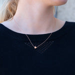 A close-up of a neck wearing a 14k Gold Asymmetrical Charm Necklace - Heart, styled with a navy knit. 