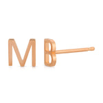Two rose gold letter stud earrings, one engraved with the letter 'M' and the other with the letter 'B'.