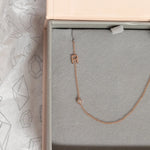 A Monogram Necklace with Diamond Rose Gold and a letter R charm in a Maya Brenner jewellery box. 