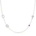 Necklace with various pendants including a clover, cross, and purple gemstone on a white background