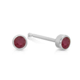 A pair of Birthstone Studs - Ruby (July) in white gold on a white background.