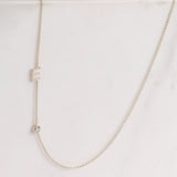 A Monogram Necklace with Diamond White Gold and a letter E charm on a light grey background. 