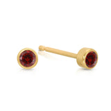 A pair of Birthstone Studs - Garnet (January) in yellow gold on a white background.