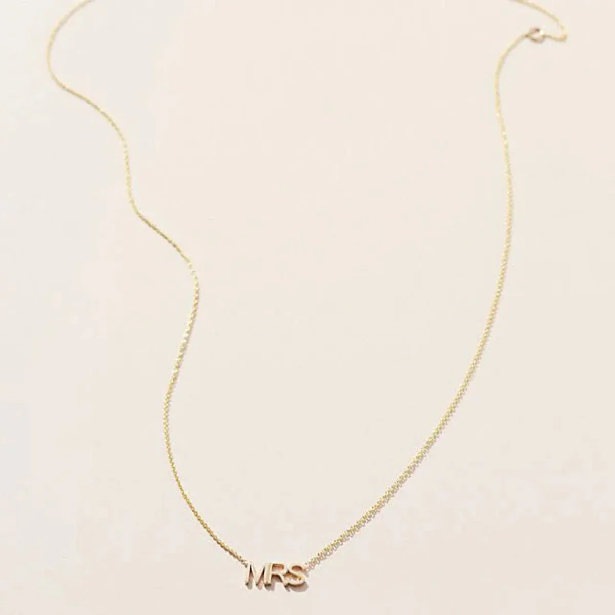 A MRS Necklace in yellow gold on a cable chain on a white background. 
