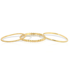 Delicate Trio Stacking Rings in yellow gold on a white background. 