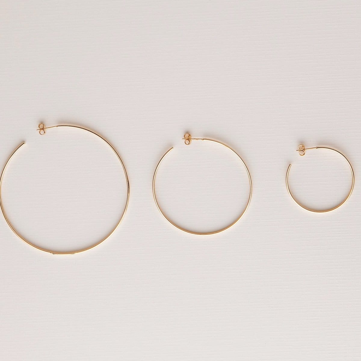 Sleek & Chic Hoops in small, medium and large against an off-white background.  