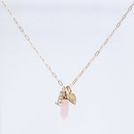 An Element Short Link Chain with a Petite Nameplate Pendant reading “teddy,” an Engraved Heart Charm, and a Balance Crystal Charm, shown against a light grey background.