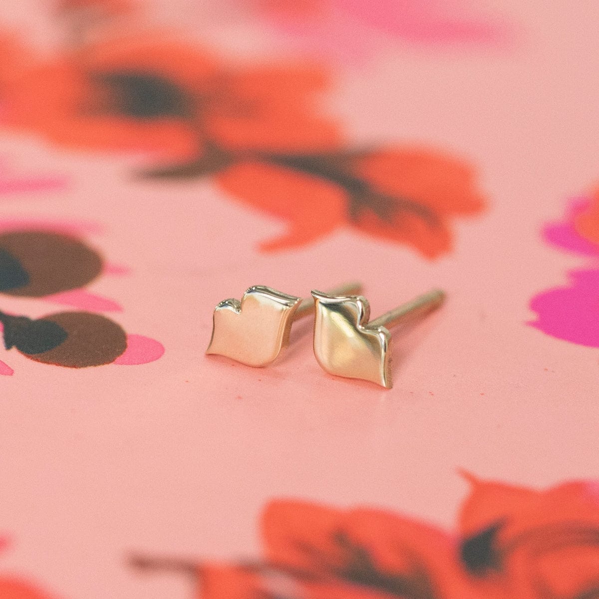 Lip Studs on a red and pink floral background. 