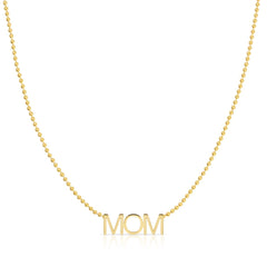 A MOM Necklace in yellow gold on a bead chain on a white background. 