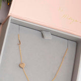 A Monogram Necklace with Heart Yellow Gold and a letter J charm in a Maya Brenner jewellery box. 