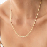 Close-up of a décolletage wearing a Chic Cuban Curb Chain in yellow gold. 