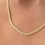 Close-up of a décolletage wearing a Chic Cuban Curb Chain in yellow gold. 