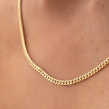 Close-up of a décolletage wearing a Chic Cuban Curb Chain in yellow gold. 