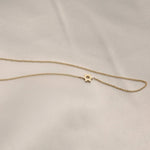 A yellow gold cable chain 14k Gold Asymmetrical Charm Necklace - Star of David against a light grey fabric background.