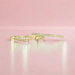 A Pavé Diamond Ring and Open Diamond Ring on a light pink background. 