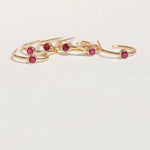Several yellow gold Birthstone Hoops in Ruby - July on a white background. 