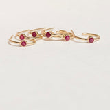 Several yellow gold Birthstone Hoops in Ruby - July on a white background. 