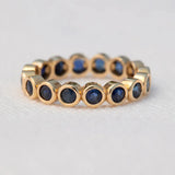 The Iris Bouquet Ring in yellow gold against a light grey background. 