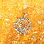 The Zodiac Necklace - Scorpio pendant laid on top of small yellow stones. 