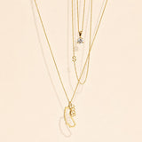 Gold necklaces with various pendants on a beige background