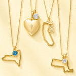 Gold necklaces with heart, state, and number 2026 pendants on a yellow background