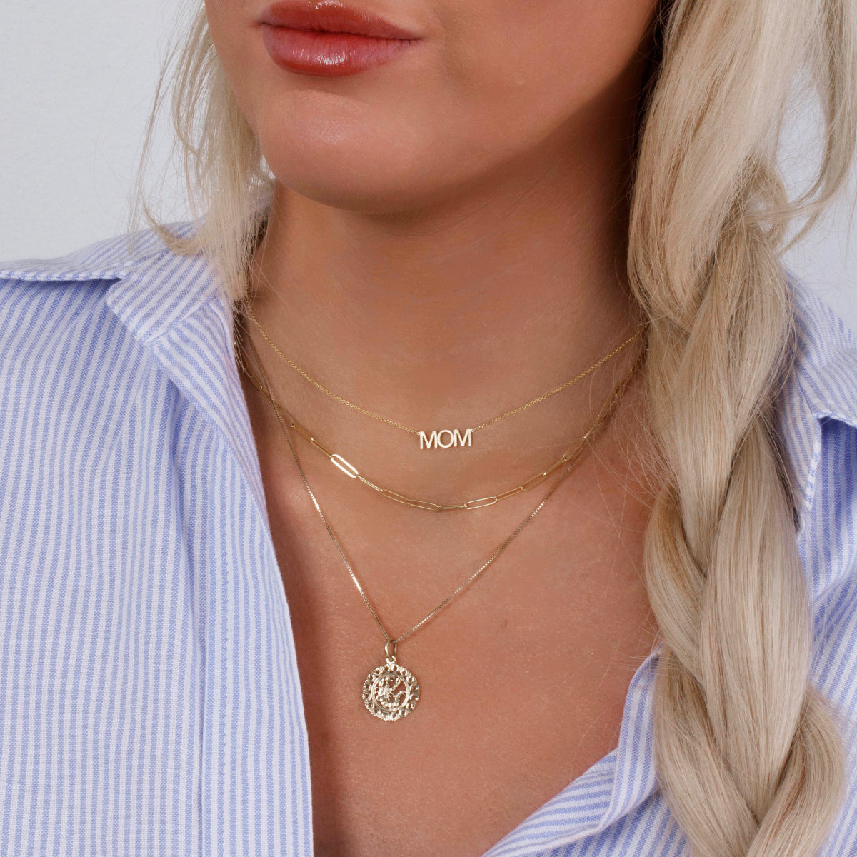 necklace with mom wordplate and link chain necklace and zodiac necklace worn with stripe blue shirt