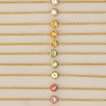 Gold necklaces with colorful gemstones on a beige background