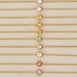 Gold necklaces with colorful gemstones on a beige background