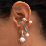 Model wearing the Maya Brenner Maxi Pearl Earring Charm on a Pavé Huggie with layered pearl earrings.