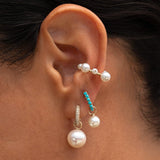 Model wearing the Maya Brenner Maxi Pearl Earring Charm on a Pavé Huggie with layered pearl earrings.