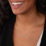 Close-up of a woman wearing multiple gold necklaces.