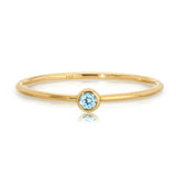 Gold ring with a blue gemstone on a white background