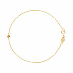 A delicate gold chain bracelet with a small round gold bead featuring a star cutout, a lobster clasp, and an adjustable extender chain with a branded tag on a plain white background.