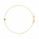 A delicate gold chain bracelet with a small round gold bead featuring a star cutout, a lobster clasp, and an adjustable extender chain with a branded tag on a plain white background.