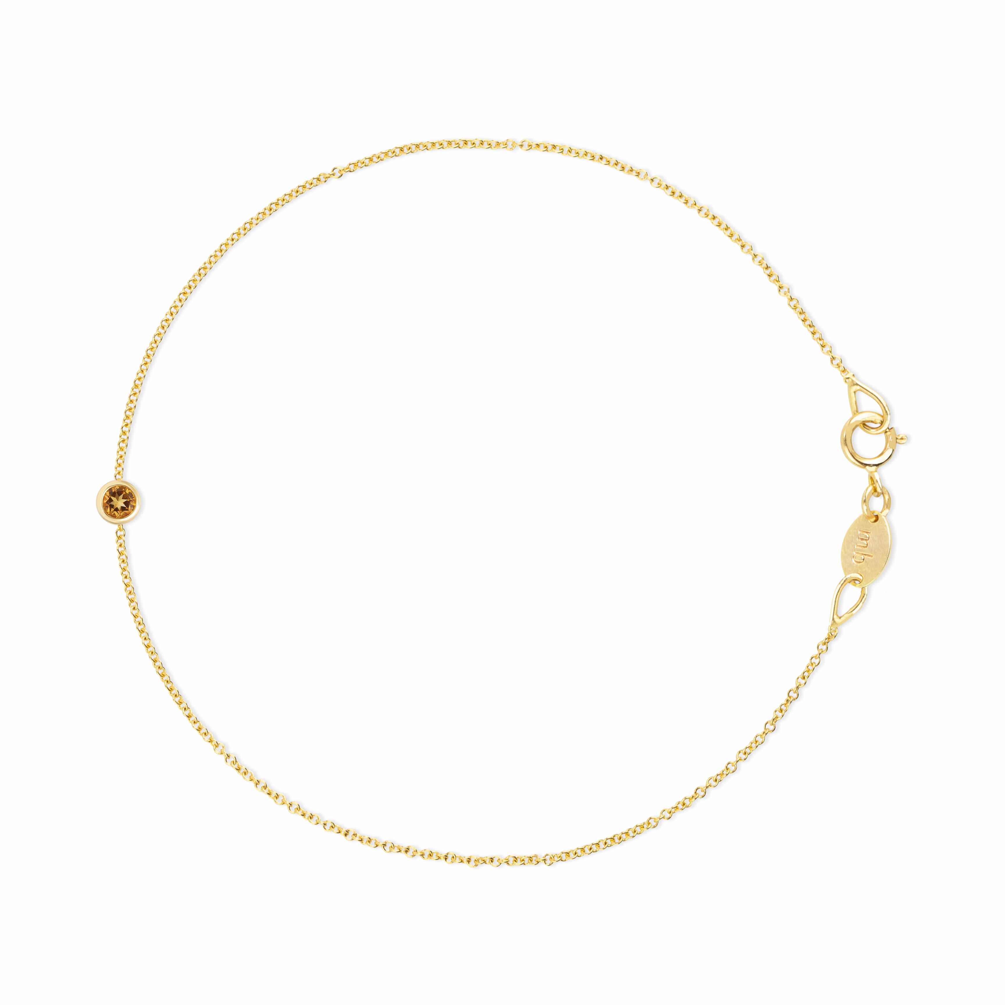 A delicate gold chain bracelet with a small round gold bead featuring a star cutout, a lobster clasp, and an adjustable extender chain with a branded tag on a plain white background.