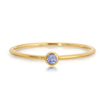 Gold ring with a purple gemstone on a white background