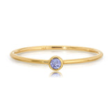 Gold ring with a purple gemstone on a white background