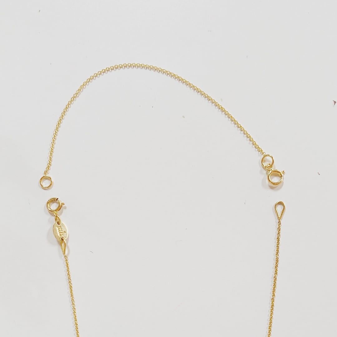 Gold chain extender on a light gray background