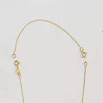 Gold chain extender on a light gray background