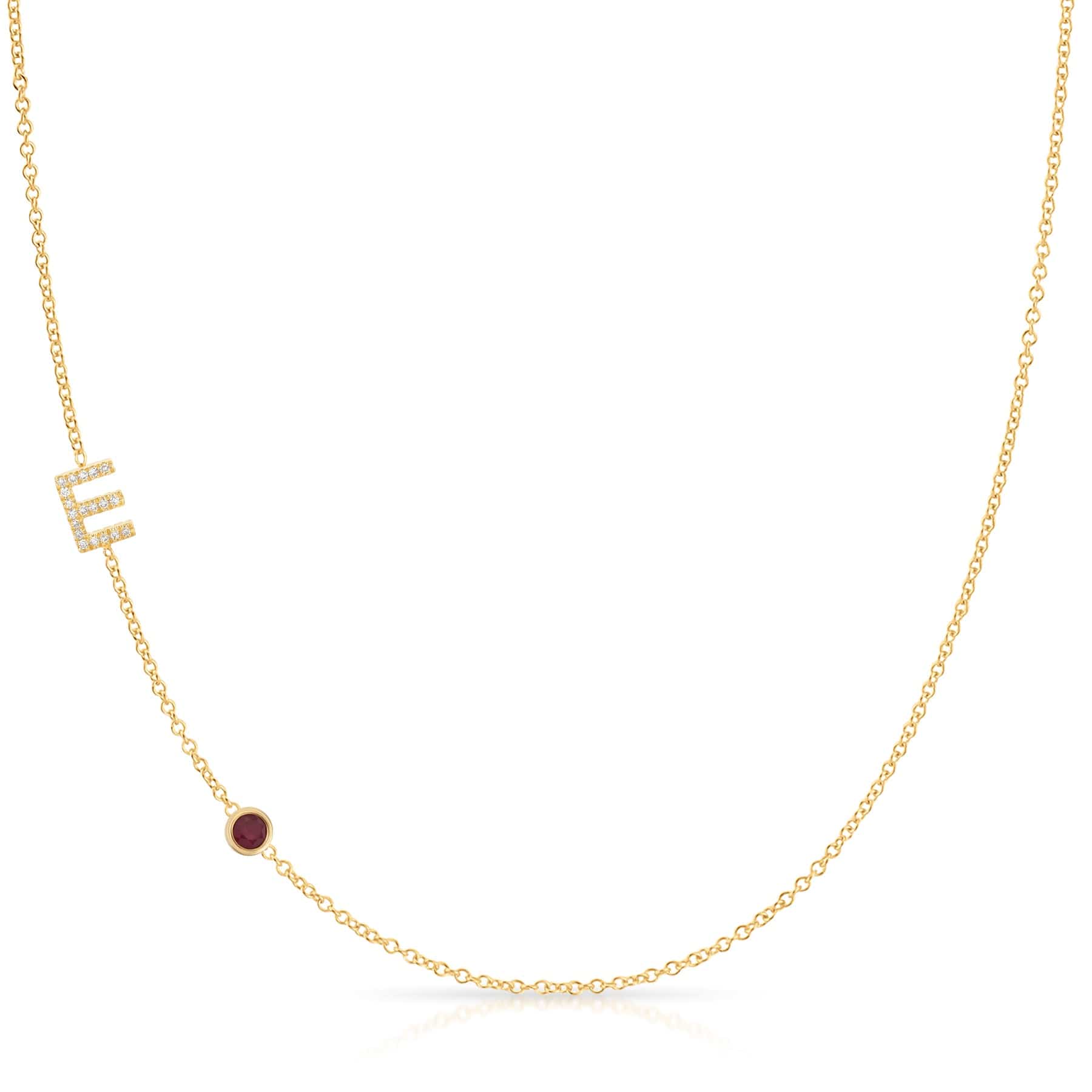 Gold necklace with a small red ruby on a white background