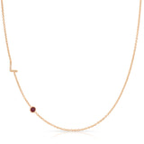 Gold necklace with a small ruby on a white background