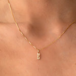 little vertical nameplate necklace on a gold chain