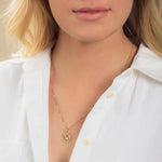 Close-up of a blonde woman wearing a Zodiac Necklace - Aries with a white shirt against a neutral background. 